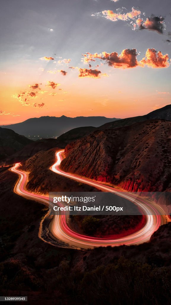 High angle view of light trails on road against sky at sunset