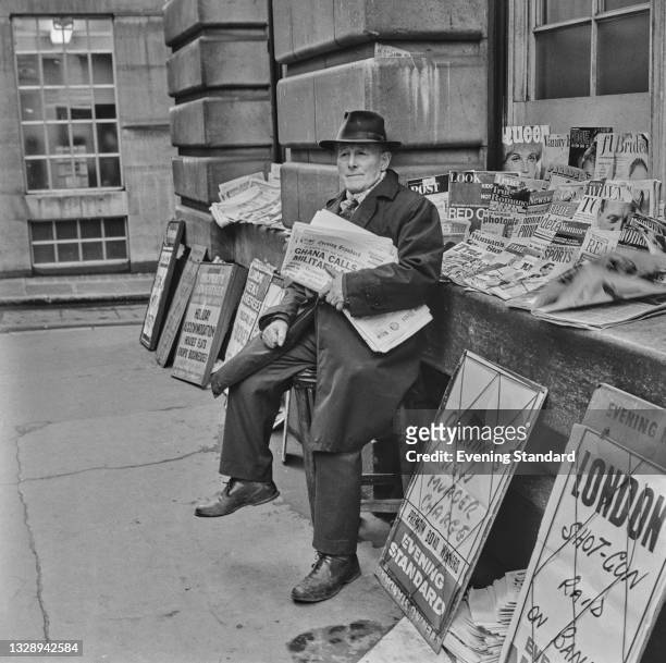 Newspaper vendor selling copies of the London Evening Standard, London, UK, 6th December 1965.