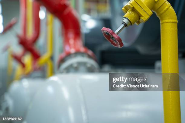 closeup of pipes and faucet valves of heating system in a boiler room. - water heater stockfoto's en -beelden