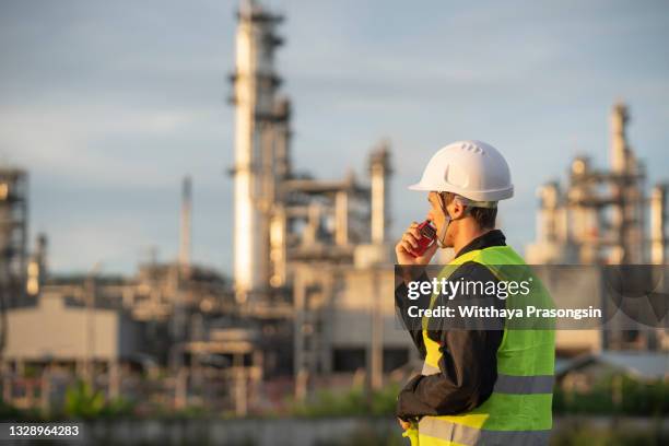 "experienced engineer overlooking oil refinery plant in a sunset, dramatic sky colors" - refinary stock pictures, royalty-free photos & images