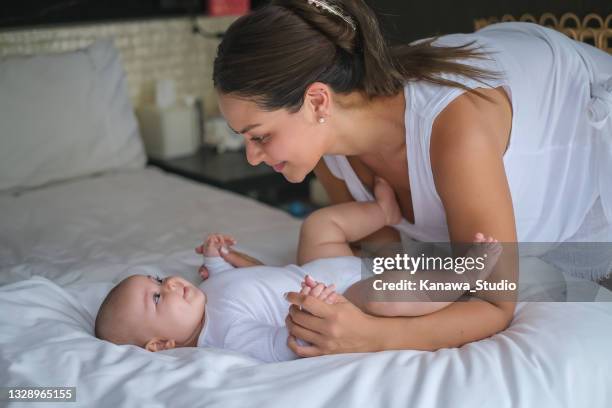 neue mutter schaut in die augen des babys für die bindung - beugen oder biegen stock-fotos und bilder