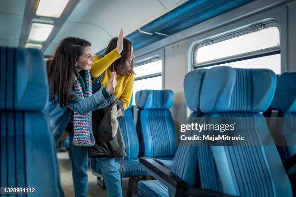 zwei freundinnen trainieren passagier winken - waving stock-fotos und bilder