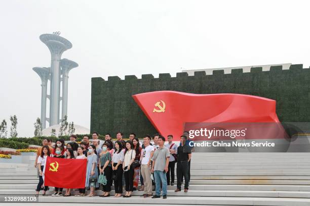 People holding the flag of the CPC pose for photos in front of the Museum of the Communist Party of China on July 15, 2021 in Beijing, China.