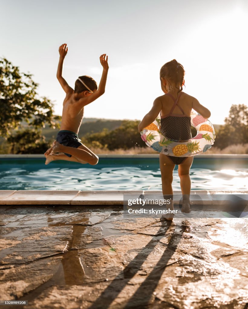 Playful siblings having fun during summer day at the pool.