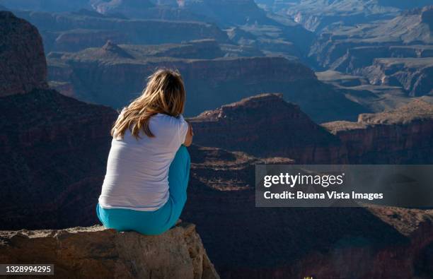 young woman watching the grand canyon - grand canyon stock-fotos und bilder