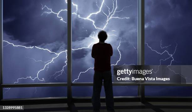 man watching thunderstorm - bad weather on window stock pictures, royalty-free photos & images