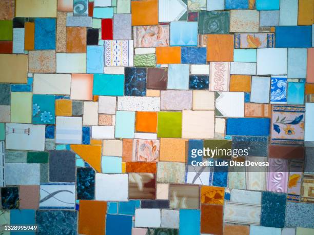 pieces of tiles on the wall forming a colored mosaics - mozaiek stockfoto's en -beelden