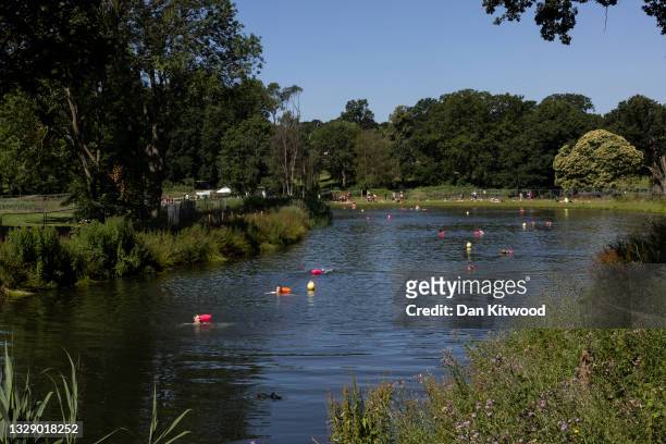 People swim in the lake at Beckenham Place Park on July 16, 2021 in Beckenham, England.