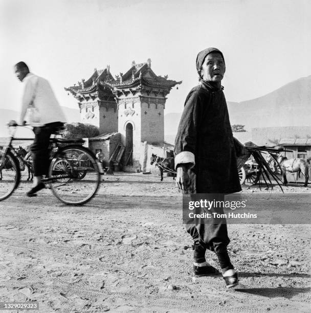 An old woman with bound feet walk in street in 1956 in Lanzhou, Gansu Province of China.