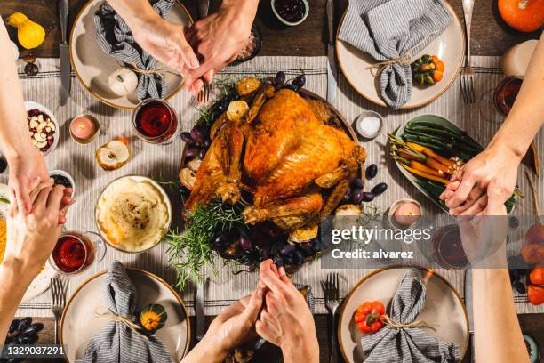 família de mãos dadas e orar durante o jantar de ação de graças - thanksgiving holiday - fotografias e filmes do acervo