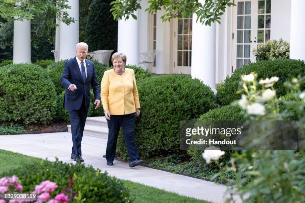 In this handout photo provided by the German Government Press Office , German Chancellor Angela Merkel and U.S. President Joe Biden walk to the joint...