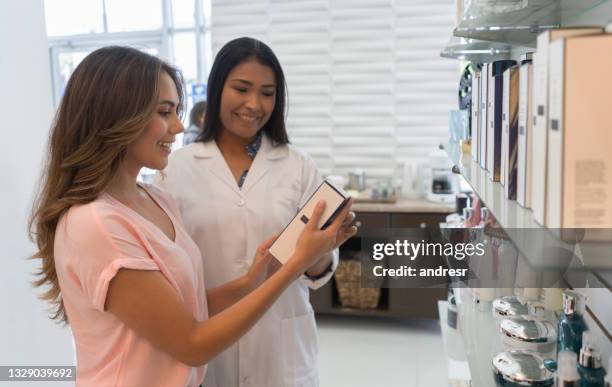 vendeuse vendant des produits de beauté à un client au salon de coiffure ou au spa - hairdresser stock photos et images de collection