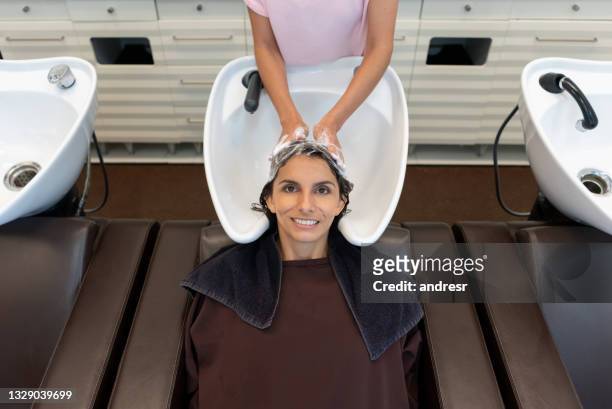 woman washing her hair at the hair salon before getting a haircut - hairdresser washing hair stock pictures, royalty-free photos & images