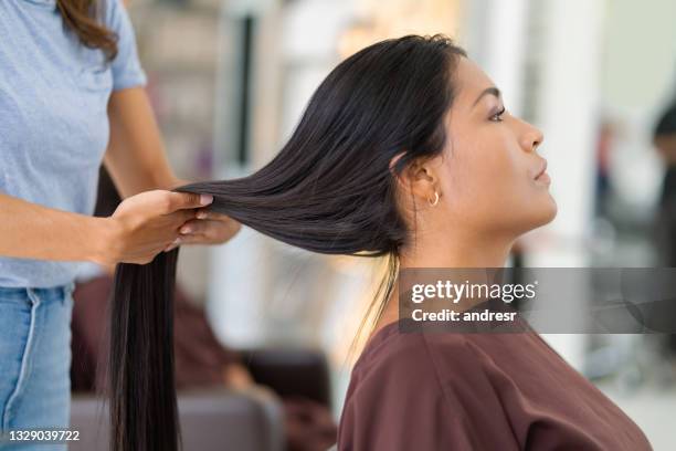 beautiful woman with long hair getting a haircut at the hair salon - straight hair stock pictures, royalty-free photos & images