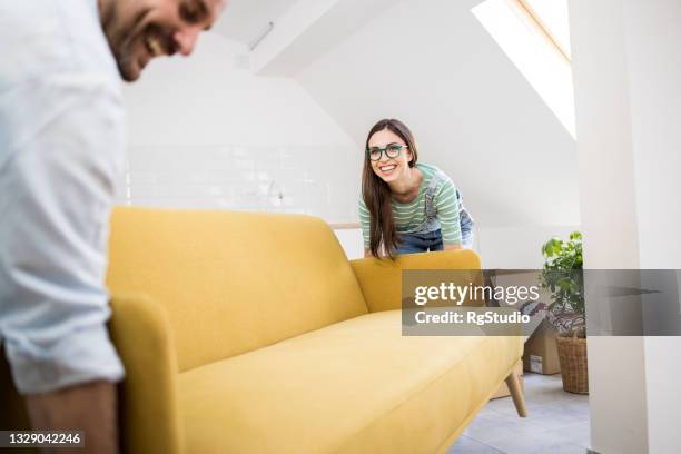 happy couple arranging their new living room - arranging stock pictures, royalty-free photos & images