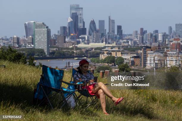 An lady relaxes in Greenwich Park on July 16, 2021 in London, England.