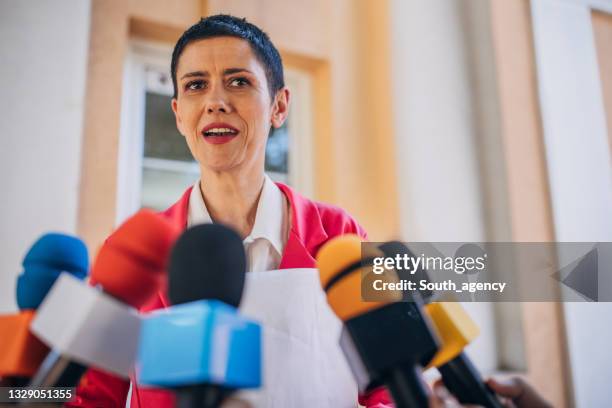 female politician speaking to reporters - politician interview stock pictures, royalty-free photos & images