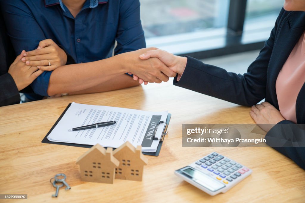 Real estate agent greeting couple at house