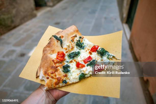 man holding a slice of pizza in venice, italy - pizza italy restuarant stockfoto's en -beelden