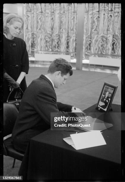 American socialite Joan Bennett Kennedy watches as her husband, US Senator Edward Kennedy signs a condolence book at the British Embassy, Washington...