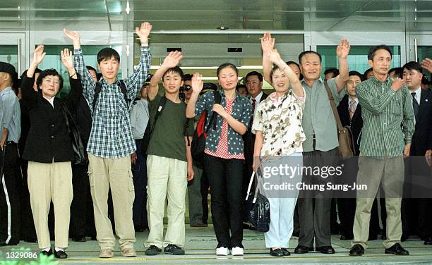 Family of seven North Koreans, aged between 15 and 69, waves to photographers June 30, 2001 in Inchon, South Korea after their arrival on an Asiana...