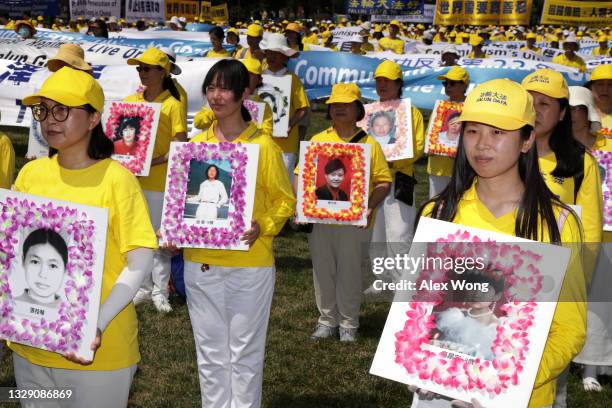 Falun Gong practitioners and supporters hold pictures of victims who were persecuted by the Chinese government as they take part in an annual rally...