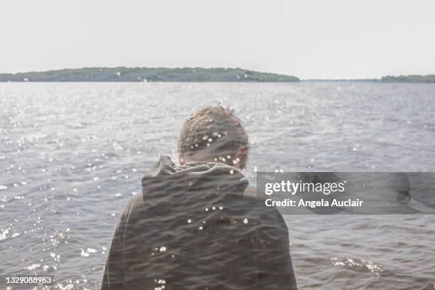 lonely teen boy double exposure - river st lawrence stock-fotos und bilder