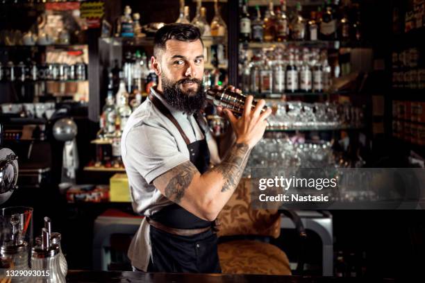 bartender making cocktails in cocktails shaker - barmen stockfoto's en -beelden