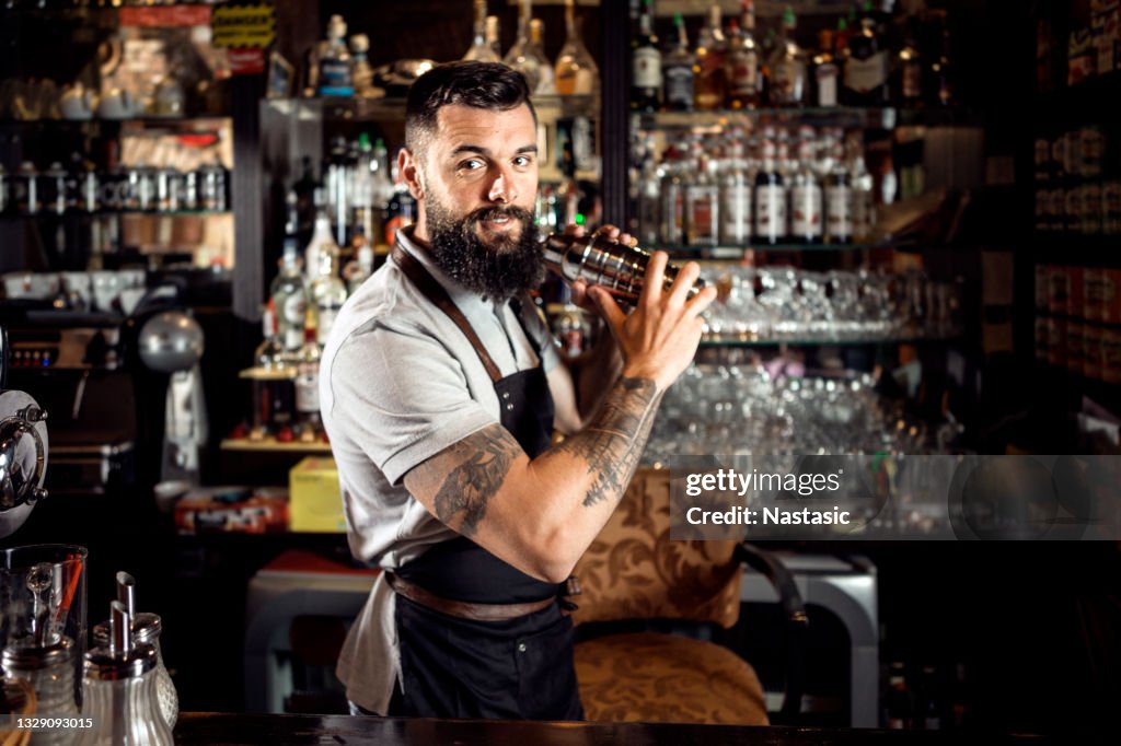 Bartender making cocktails in cocktails shaker