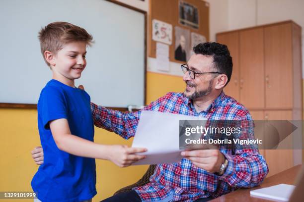 teacher giving test results to his happy student - teacher taking attendance stock pictures, royalty-free photos & images