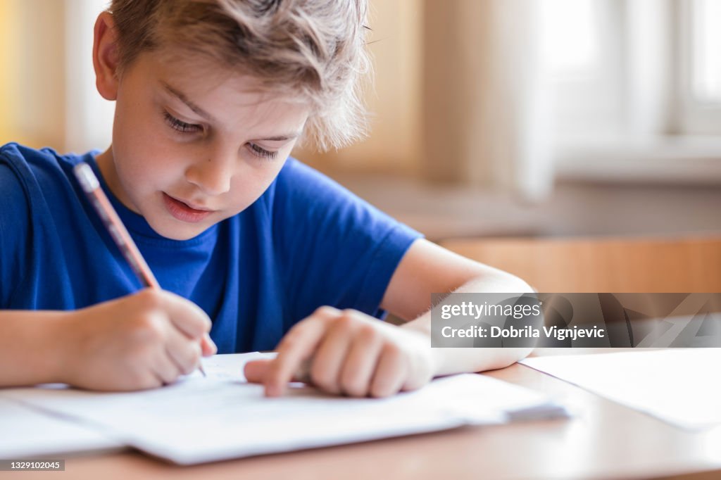 Boy taking notes at class