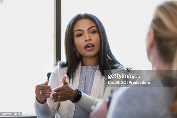 mid adult female lawyer gestures while advising female client - office serious stock pictures, royalty-free photos & images