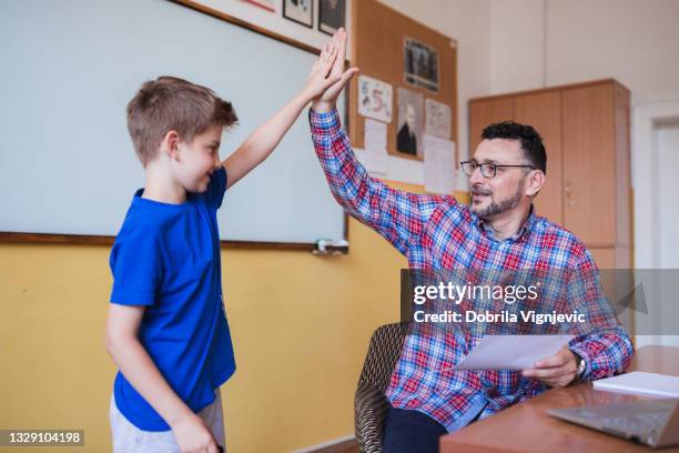 teacher and student having a high-five interchange at classroom - teacher taking attendance stock pictures, royalty-free photos & images