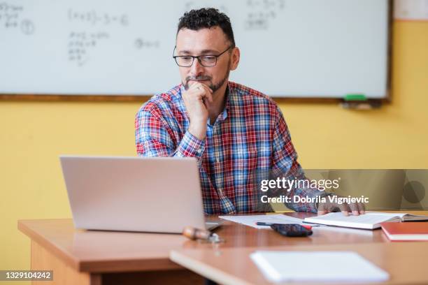 lehrer, der am laptop arbeitet - lehrer stock-fotos und bilder