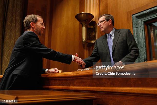 Senate Budget Committee Chairman Sen. Kent Conrad greets Congressional Budget Office Director Doug Elmendorf before a hearing on Capitol Hill...