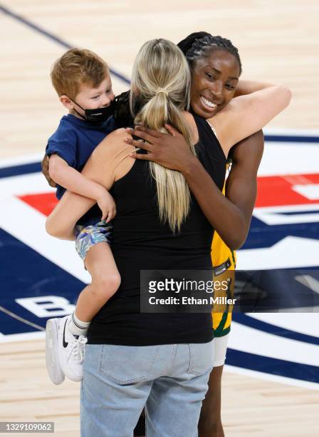 Former WNBA and Australia women's national basketball team player Penny Taylor holds her son Leo Michael Taurasi-Taylor as she hugs Ezi Magbegor of...