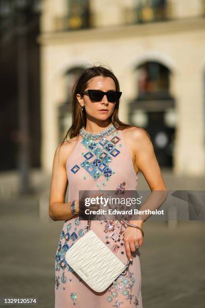 Julia Comil wears a pink silky sheer embroidered and bejeweled midi dress from Miu Miu, a white "matelassé" nappa quilted leather Bag from Miu Miu,...