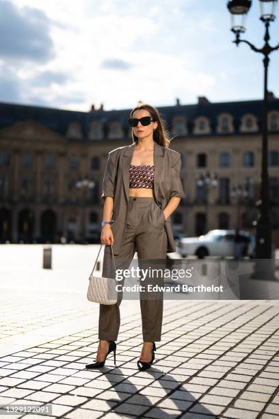 Julia Comil wears an oversized dark green blazer jacket by American Vintage, matching suit tapered wool trousers in dark green by American Vintage, a...