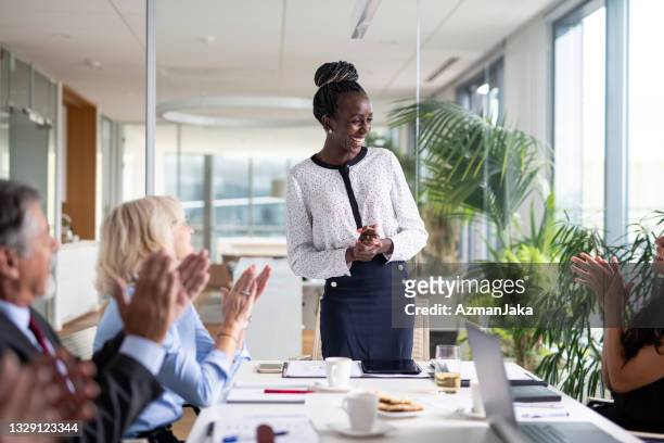 diverse group of executives applauding african female ceo - dankbaarheid stockfoto's en -beelden