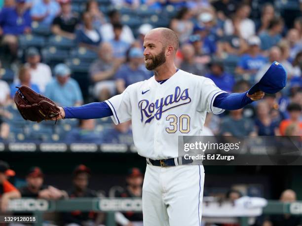 Starting pitcher Danny Duffy of the Kansas City Royals offers his cap and glove to be checked after throwing in the first inning aBaltimore Orioles...