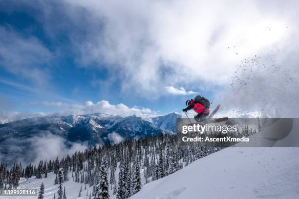 downhill skier gets air off snowy mountain ridge - extreem skiën stockfoto's en -beelden