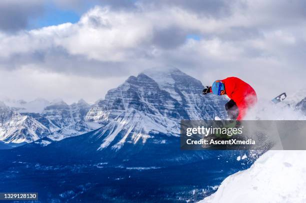 downhill skier gets air off snowy mountain ridge - extreme skiing stock pictures, royalty-free photos & images