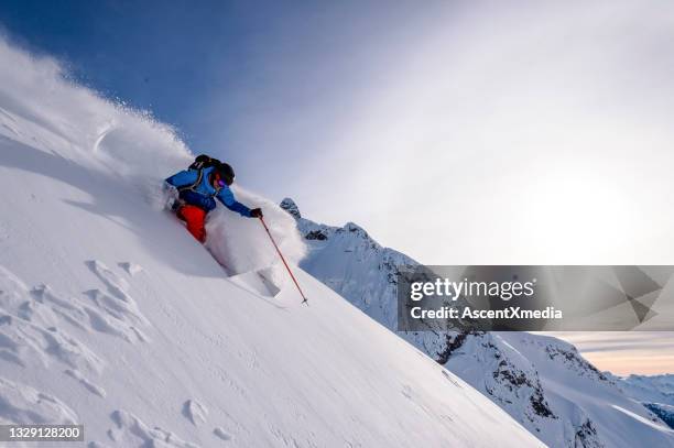 backcountry skier descends snowy mountain ridge - montanhas rochosas canadianas imagens e fotografias de stock