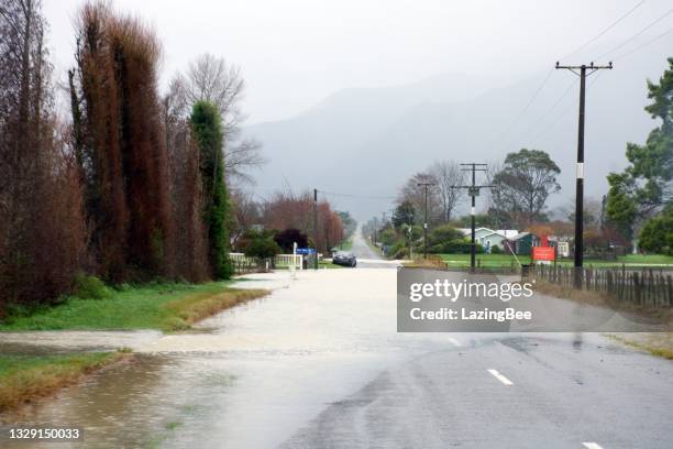 takaka river floods onto long plain road in the tasman district, in new zealand's south island - tasman district new zealand stock pictures, royalty-free photos & images