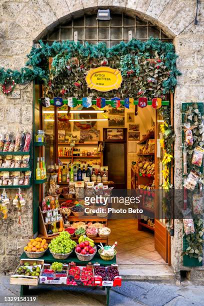 a colorful and typical italian gourmet shop along a stone alley in the medieval heart of siena in tuscany - county_fair stock pictures, royalty-free photos & images