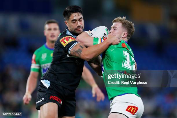 Hudson Young of the Raiders is tackled by Shaun Johnson of the Sharks during the round 18 NRL match between the Canberra Raiders and the Cronulla...