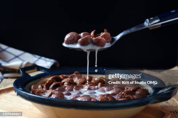 milk spilled from a spoon of cereal and milk - céréale photos et images de collection
