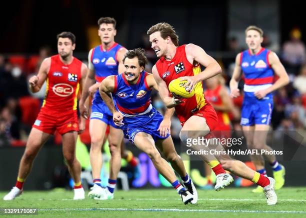 Noah Anderson of the Suns runs with the ball during the round 18 AFL match between Gold Coast Suns and Western Bulldogs at Metricon Stadium on July...