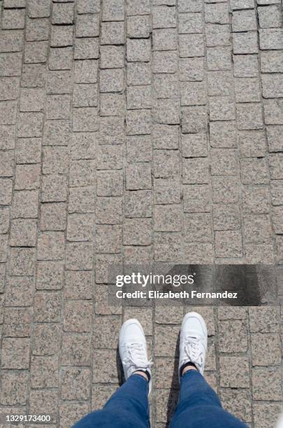 low section of woman standing on cobblestone street - parte inferior imagens e fotografias de stock