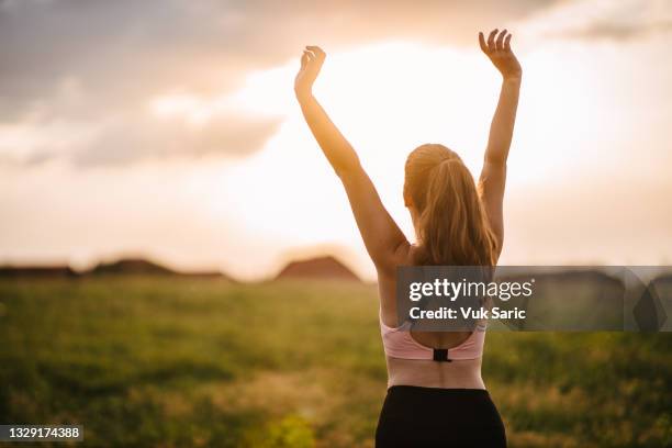 woman stretching on the meadow - vitamin d stockfoto's en -beelden